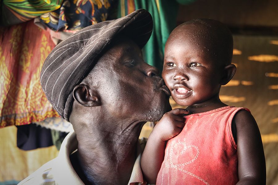 Majok kisses his daughter on the cheek.