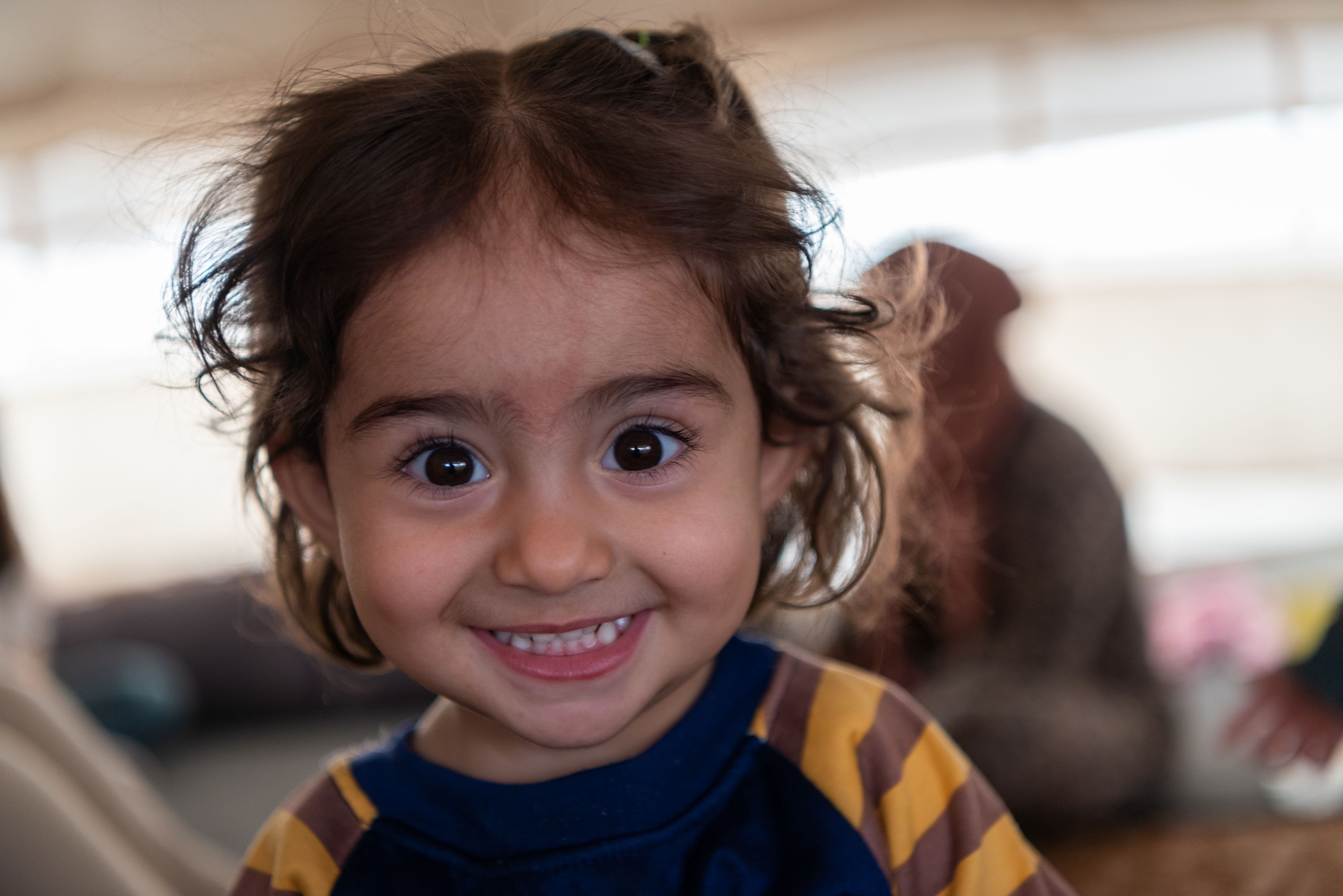 Small girl looks into the camera up-close.