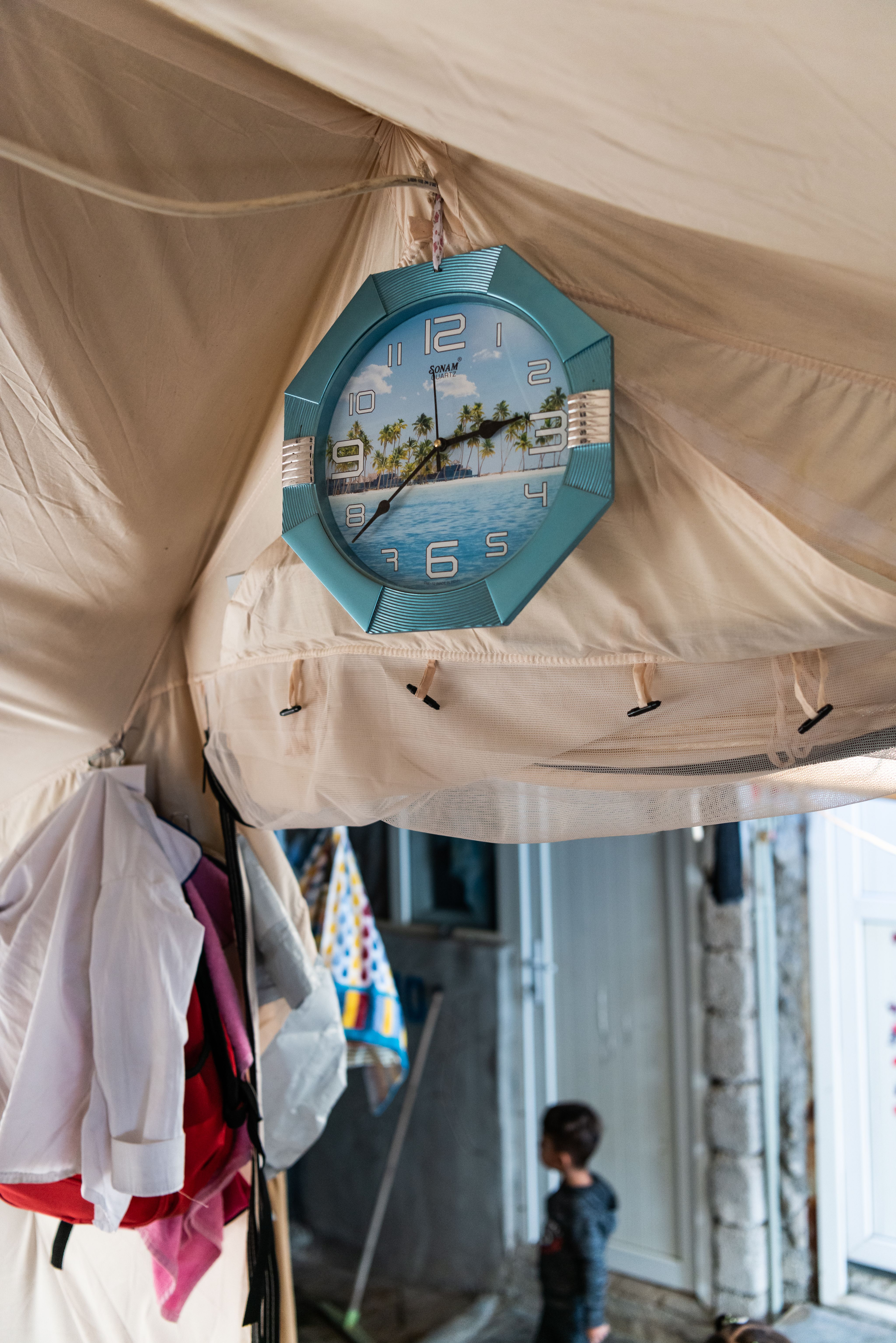 A tropical clock is hung up in Kamla's tent.