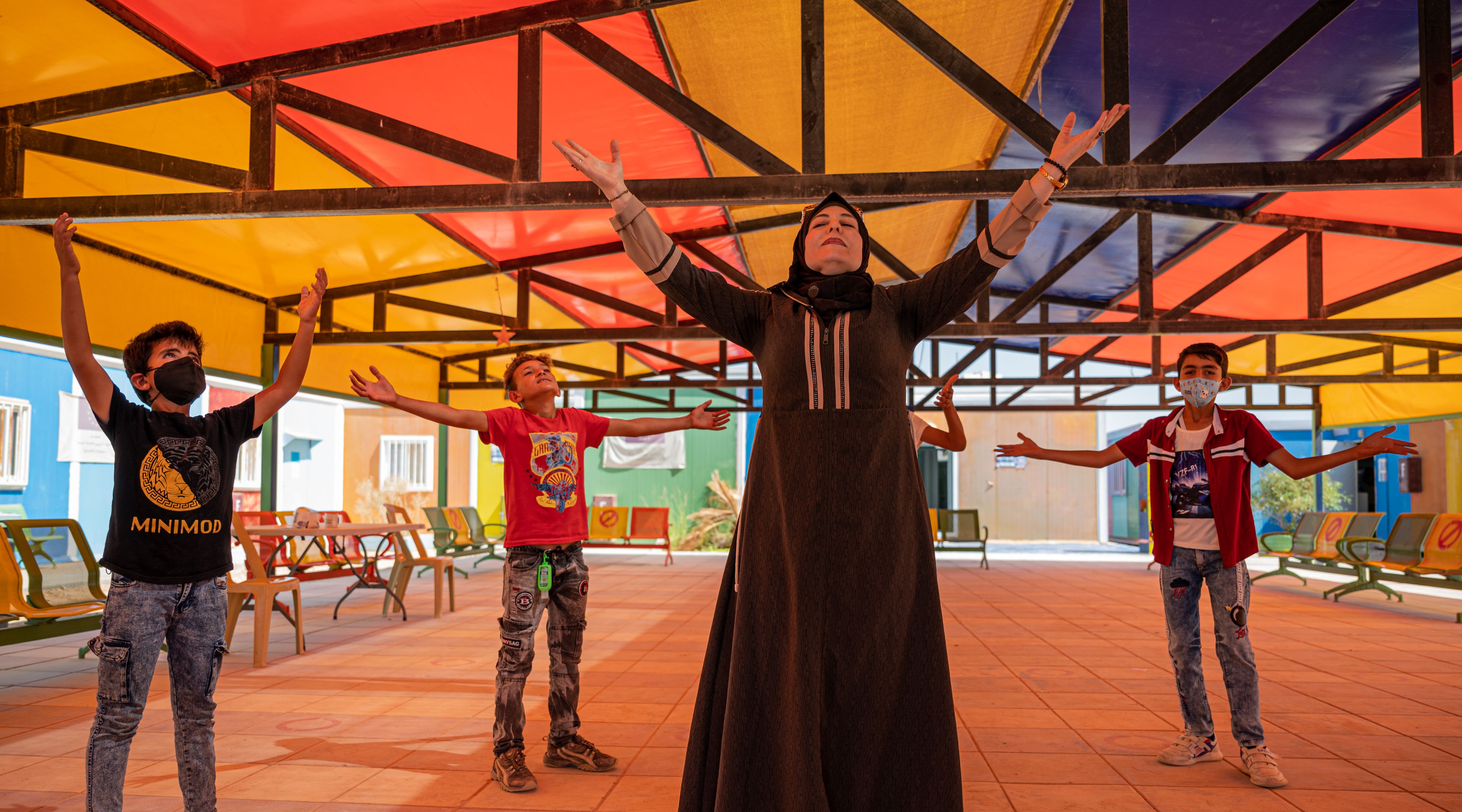 A Syrian teacher performs mindfulness exercises with Syrian refugee children at Azraq Refugee Camp in Jordan
