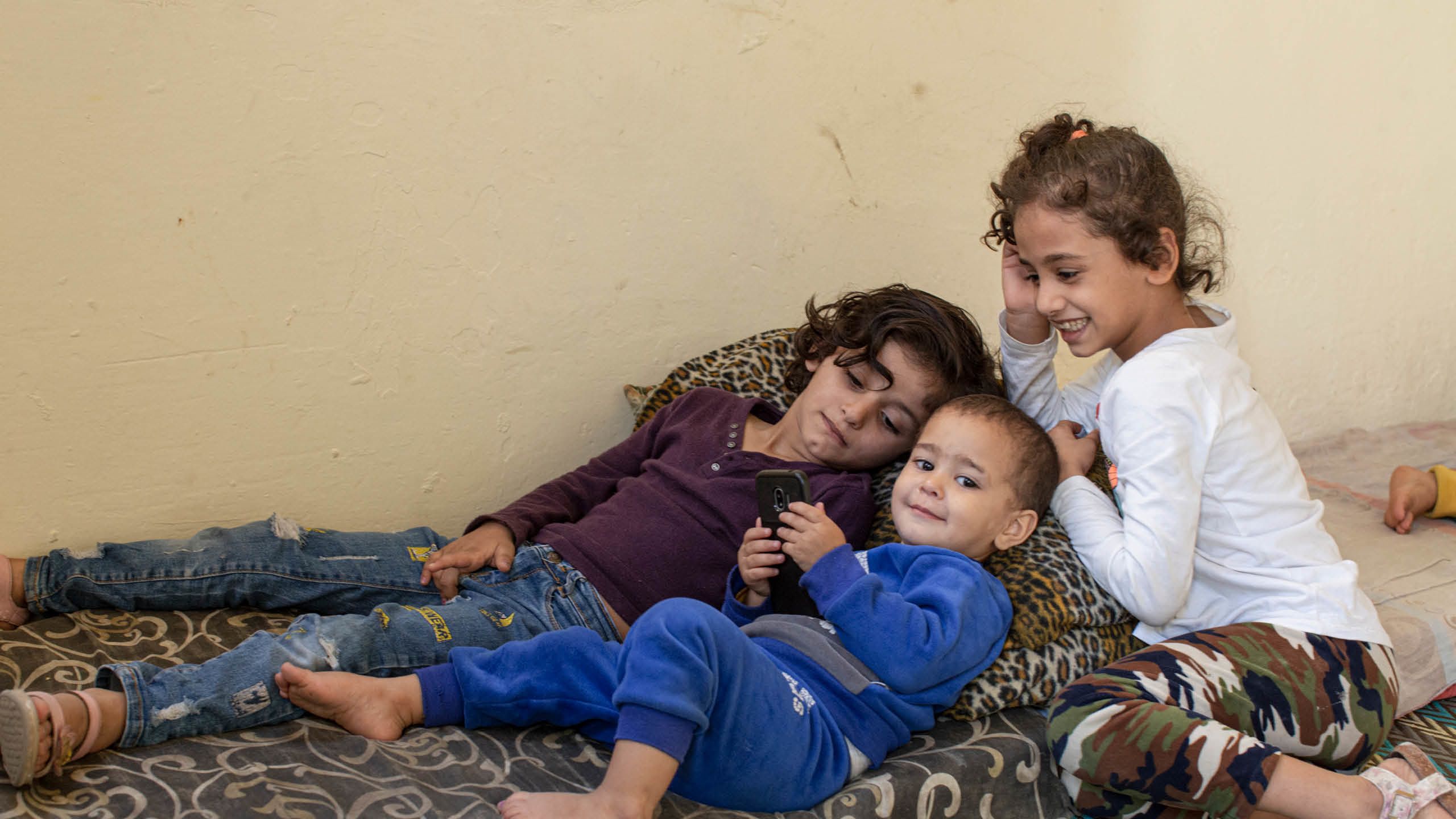 Jude, 6 år och Fatima, 7 år leker med sin lillebror Doaa, 1 år.