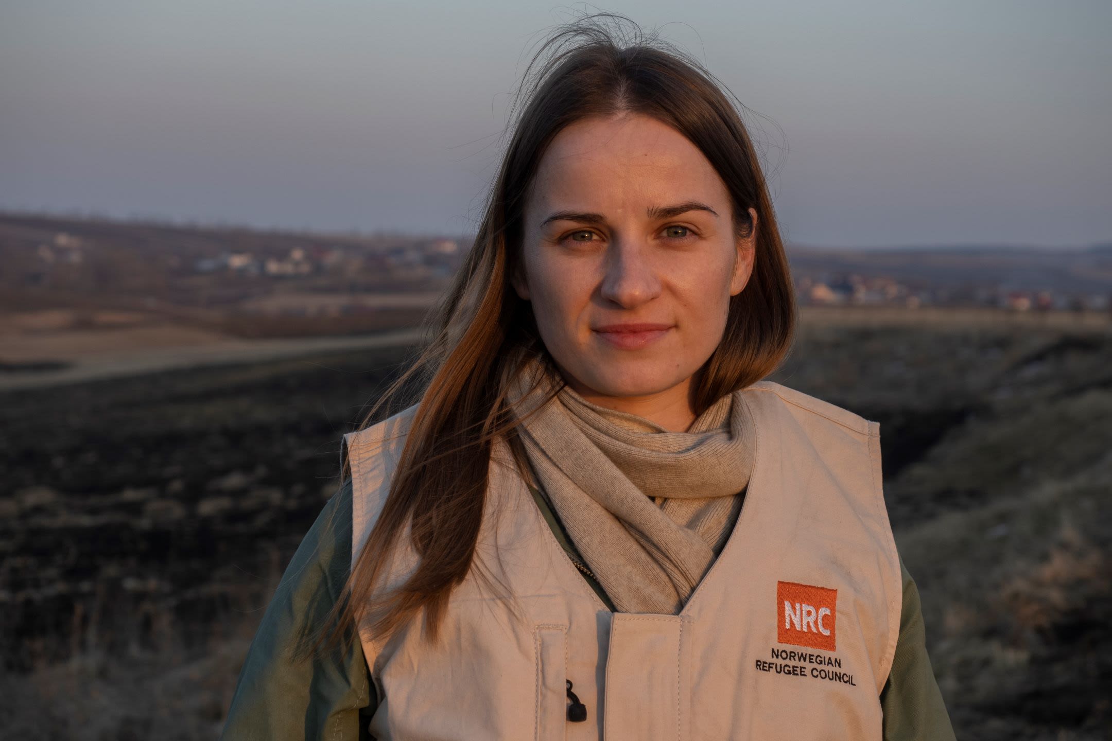 A woman looking at the camera, wearing a NRC vest.